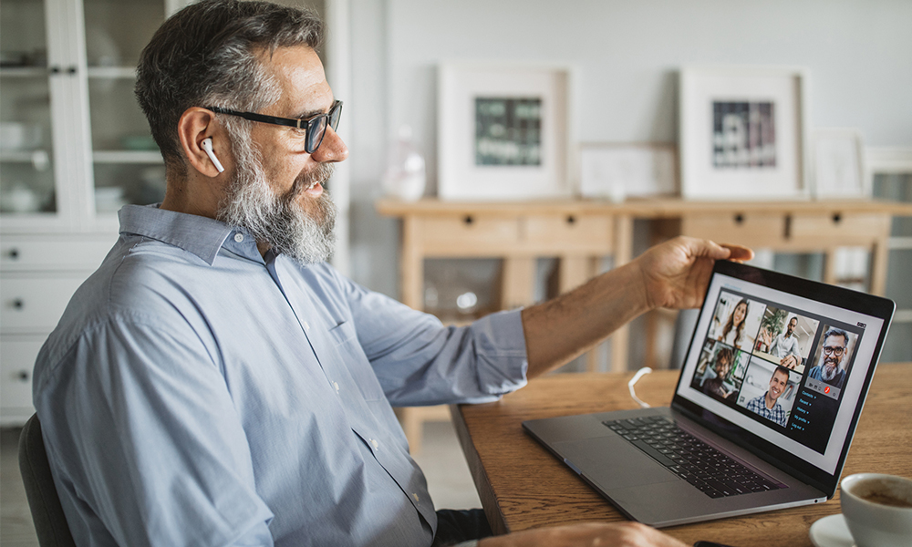 Older man on a video call with colleagues.